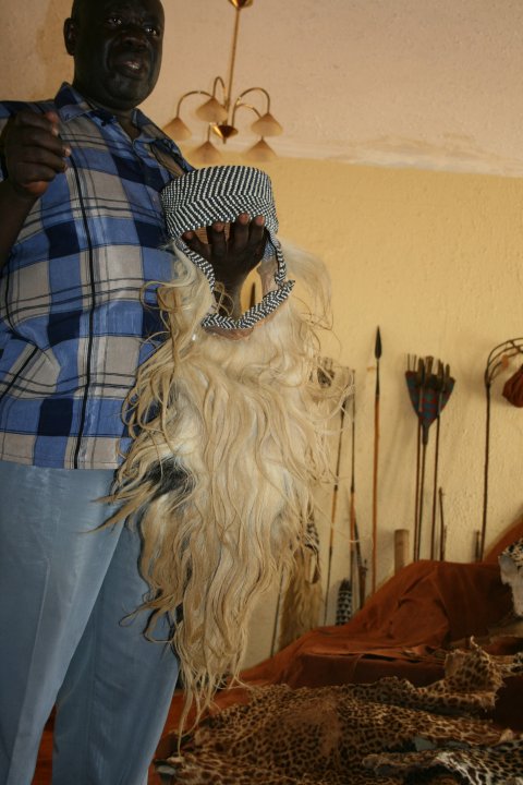 De secretaris van de koning die uitleg geeft en hier met een kroon in zijn hand waar leeuwenmanen als baard in verwerkt zijn.